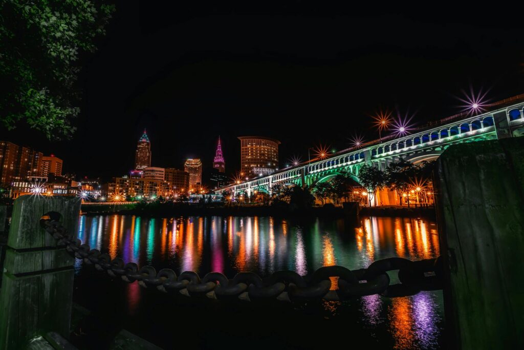 Stunning night view of Cleveland skyline and illuminated bridge reflecting on the river.