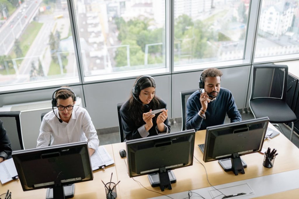 Diverse call center team working in a bright office space with a city view.